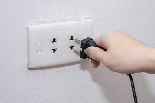 Unplug or plugged in concept, Female hand holding and pull electric plug with copy space