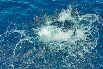 Water splash on the red sea after a jump from a yacht background texture