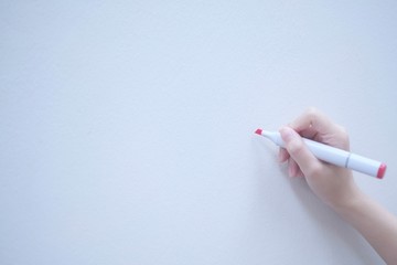 Red pen and human hand on copy space whiteboard