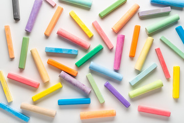 flat lay of different multicolor chalks like background on white, concept of education or business