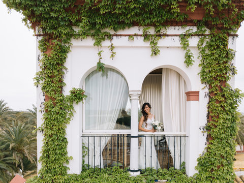 Beautiful woman bride with wedding dress posing in balcony