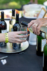 opening a bottle of wine and pouring into glass