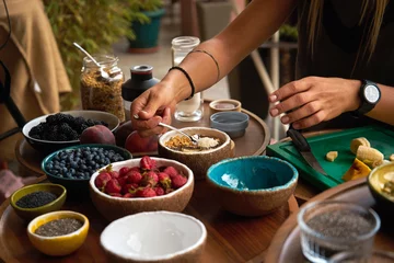 Foto op Plexiglas woman making smoothie bowl for breakfast. many useful fruits © Himchenko