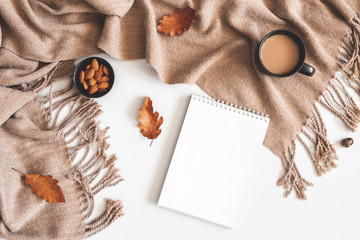 Autumn composition. Cup of coffee, plaid, notepad, autumn leaves on white background. Flat lay, top...