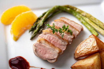 sliced roasted duck with red wine sauce and orange