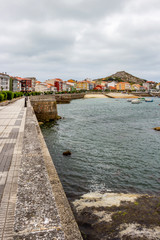 Overcast summer marina view with promenade in Muxia or Mugia on the Way of St. James, Camino de Santiago, Province of A Coruna, Galicia, Spain