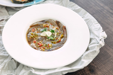 Fish Sauce-Fermented raw shrimps with fresh garlic and chili served in white plate.
