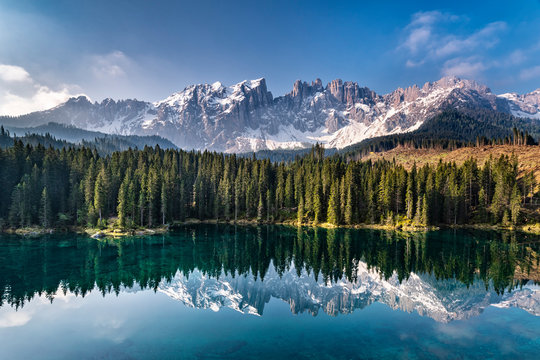 Scenic view of Karersee lake with snowcapped mountains in background