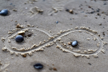 Infinity symbol drawing on sand. Close up