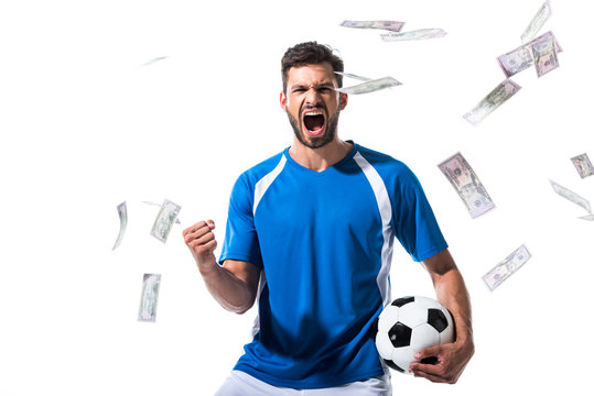 soccer player with ball cheering with clenched hand near falling money Isolated On White