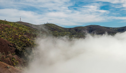 Fototapeta na wymiar Sea of clouds emerging between the hills