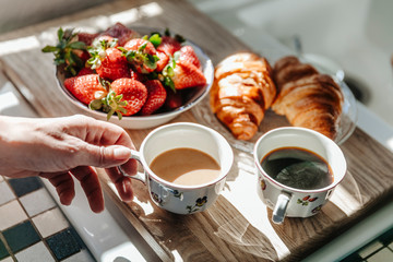 Strawberries, croissants and coffee in kitchen