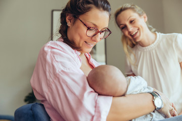 Midwife supporting a breastfeeding mother with her newborn baby