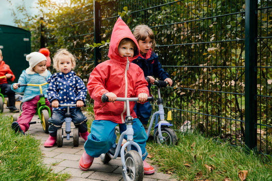 Children using scooters in garden of a kindergarten