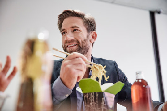 Businessman having lunch break with Asian food