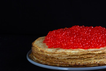 Stack of porous blini with red caviar on the top