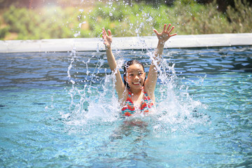 Ein Mädchen planscht in einem Swimmingpool