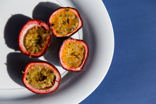 Fresh Passion Fruit On Ceramic Plate On A Pastel Pink Background In Top View. Ripe Tropical Passion Fruit Close Up. Dessert Of Vegetarian Diet. Intermittent Fasting Diet. Healthy Snack.