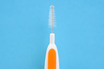 Macro shot of specialized interdental toothbrush for cleaning teeth and braces system on a blue...