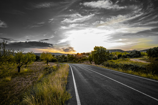 Panoramic view of an empty road with back light during a cloudy spring day and mountains - Image
