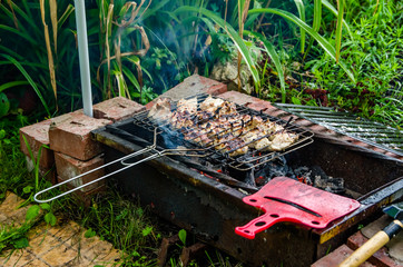 kebab is fried on a grill in the garden