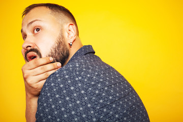 Profile portrait of scared charismatic 35 years old man posing over yellow background. Short modern...