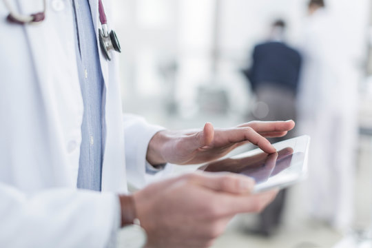 Close-up of doctor using a digital tablet - Powered by Adobe