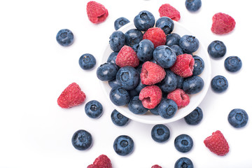 raspberries and blueberries on white 