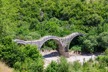 The stone Plakidas bridge (Kalogeriko) with dried up river in Zagori region (Vikos Gore national...