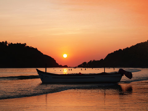 India Palolem beach sunset with boat silhouette