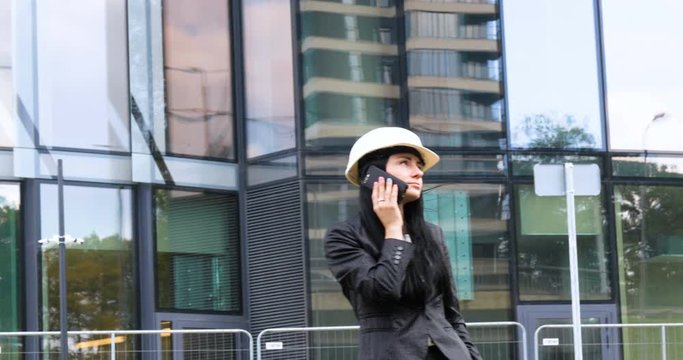 Happiness businesswoman calling by phone on the business architecture background. Concept of: Skyscraper,  Business girl, Architect, Lifestyle.