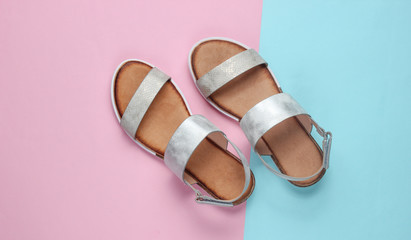 Leather female sandals on a pastel blue-pink background. Summer footwear, Top view