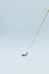 golf club near golf ball on tee on grey background