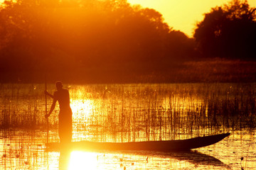 Traditional African canoe sunset. Okavango delta Botswana.