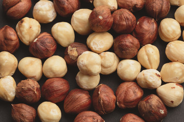 hazelnut nuts scattered on black paper background