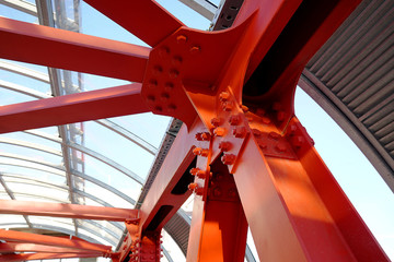 Red iron beams bolted on. Angular connection of several iron beams in one place. Pedestrian...