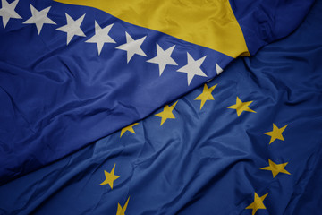 waving colorful flag of european union and flag of bosnia and herzegovina.