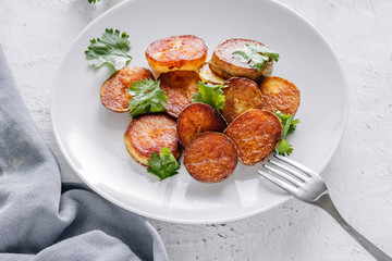 Baked potatoes with cilantro in a plate