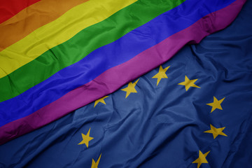 waving colorful flag of european union and gay rainbow flag .