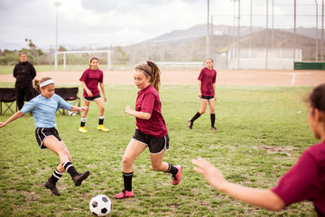 Girls playing soccer on sports field © Cavan for Adobe