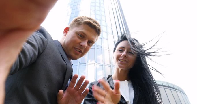 Fun Young Couple Taking Selfie With Mobile Phone on skyscraper background. Concept of: Suite, Business, Couple, Architecture, Smartphone, Lifestyle, 5g network.