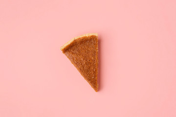 One pumpkin pie on pink background. Last pie slice