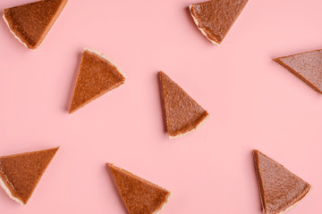 Pattern of pumpkin pie slices on pink background