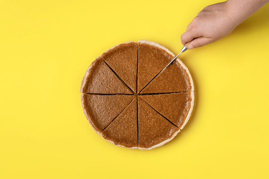 Woman Hand Cutting A Pumpkin Pie