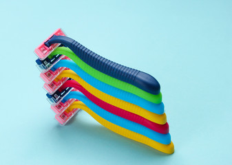 Stack of colored plastic razors on blue background