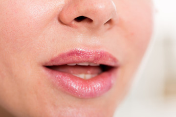 Naklejka premium Close-up of female's lips with natural lipstick make up. macro lipgloss make-up