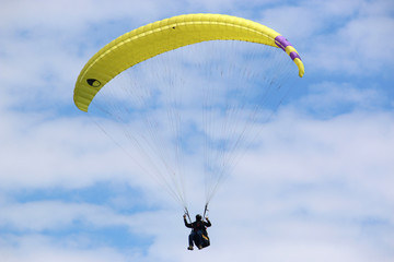 paraglider flying in a blue sky