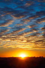Urban landscape with sunset, cirrus clouds and buildings, vertical view
