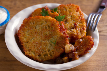 Potato pancakes with bacon and sour cream. Vegetable fritters, draniki - popular dish in many countries