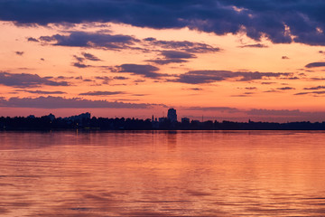Fototapeta premium lake and city on the background of a colorful sunset